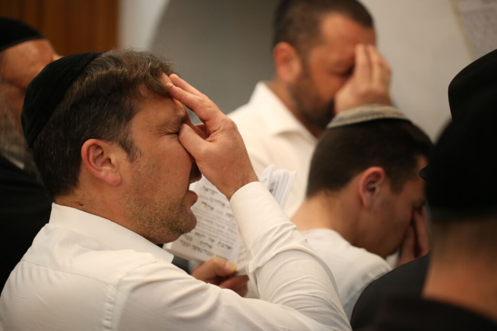 A Jewish man touches his forehead in prayer